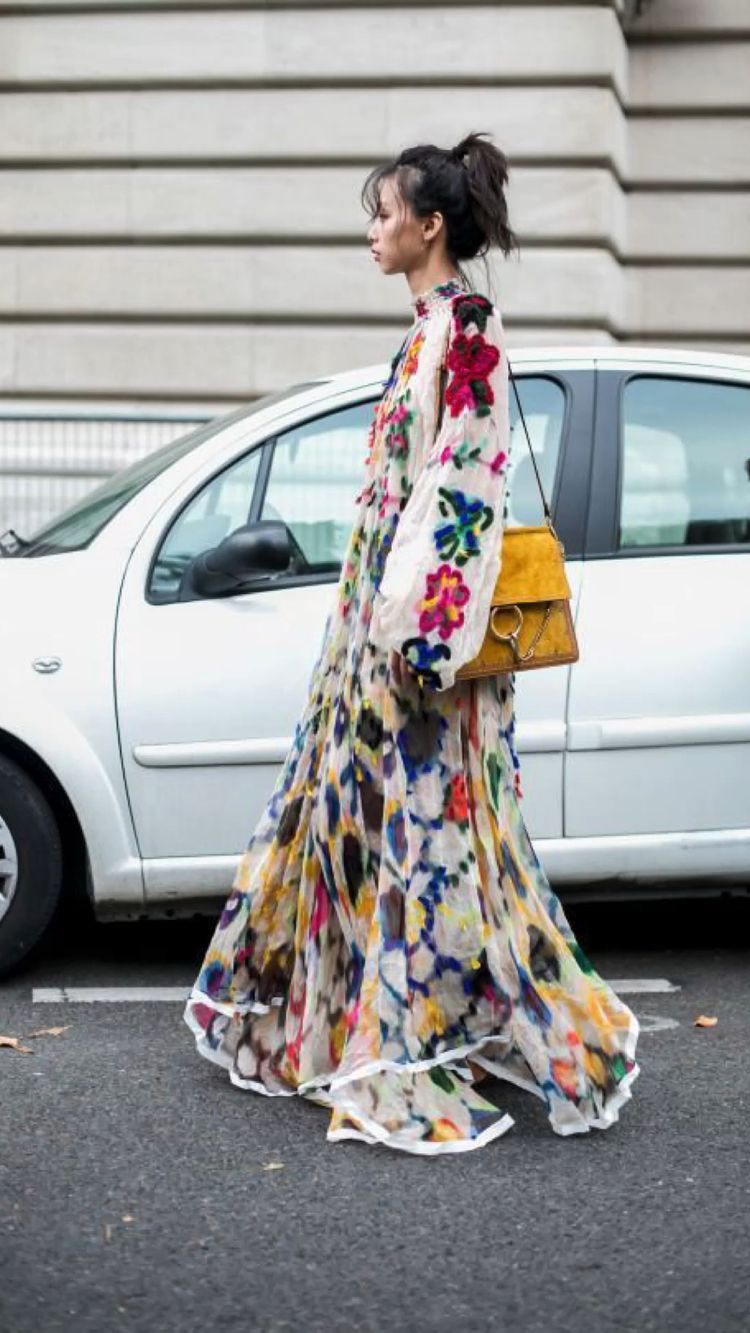 Donna che indossa un lungo vestito a fiori per strada